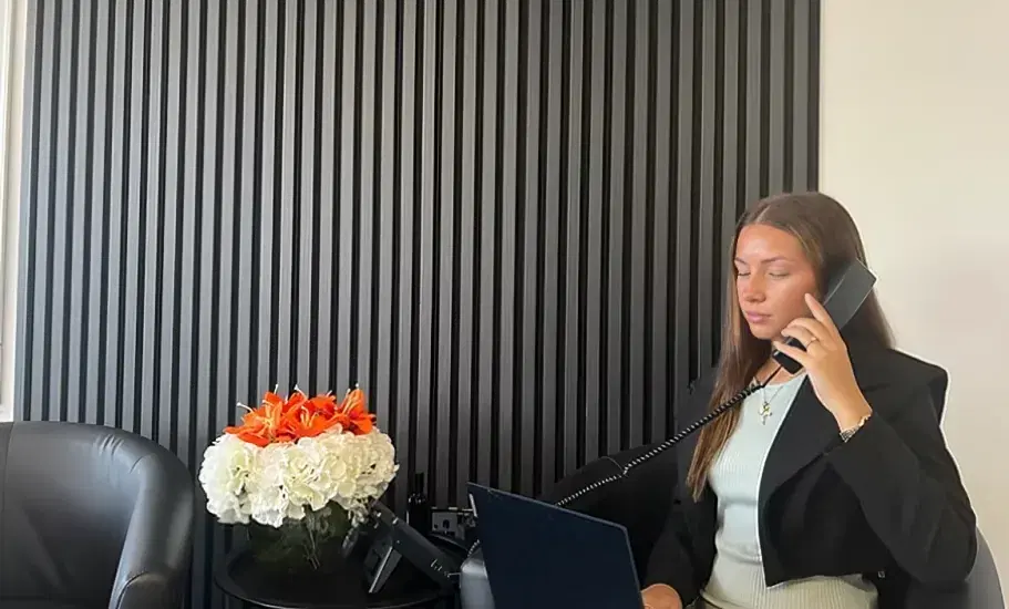 A member of the Metrick team taking a call at their office reception desk