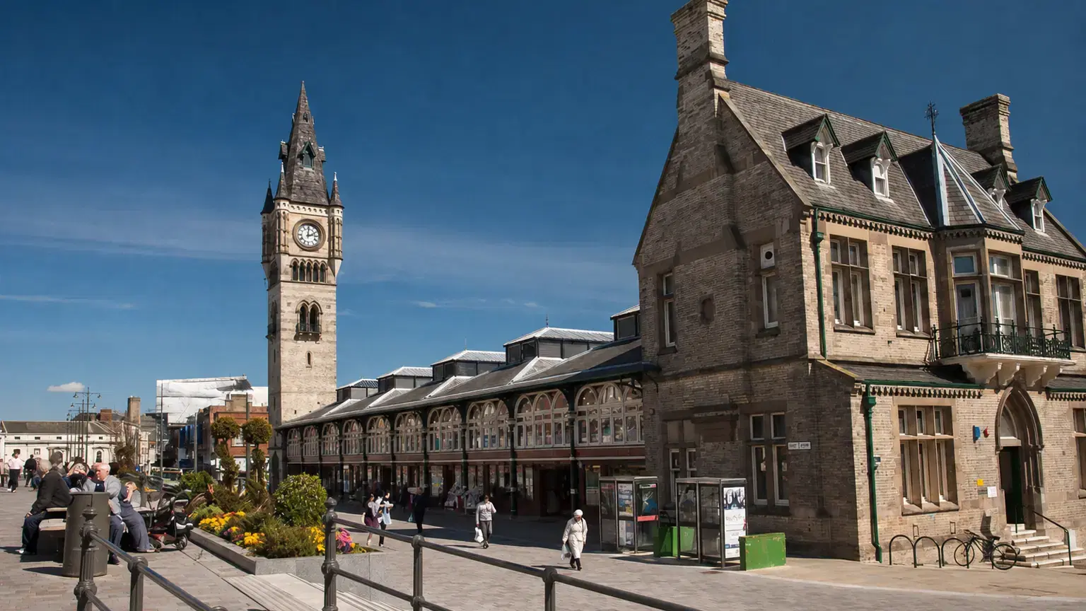 Darlington High Row, with the clock tower and covered market hall in the sunshine.