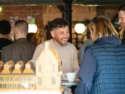 Two attendees laughing over a coffee at a Darlington First coffee morning.