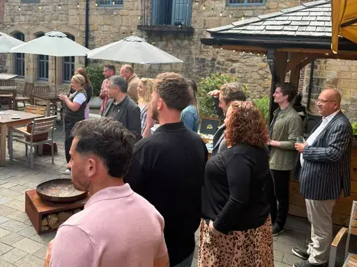 Attendees gathered under parasols in the Blackfriars courtyard at a Newcastle First coffee morning.